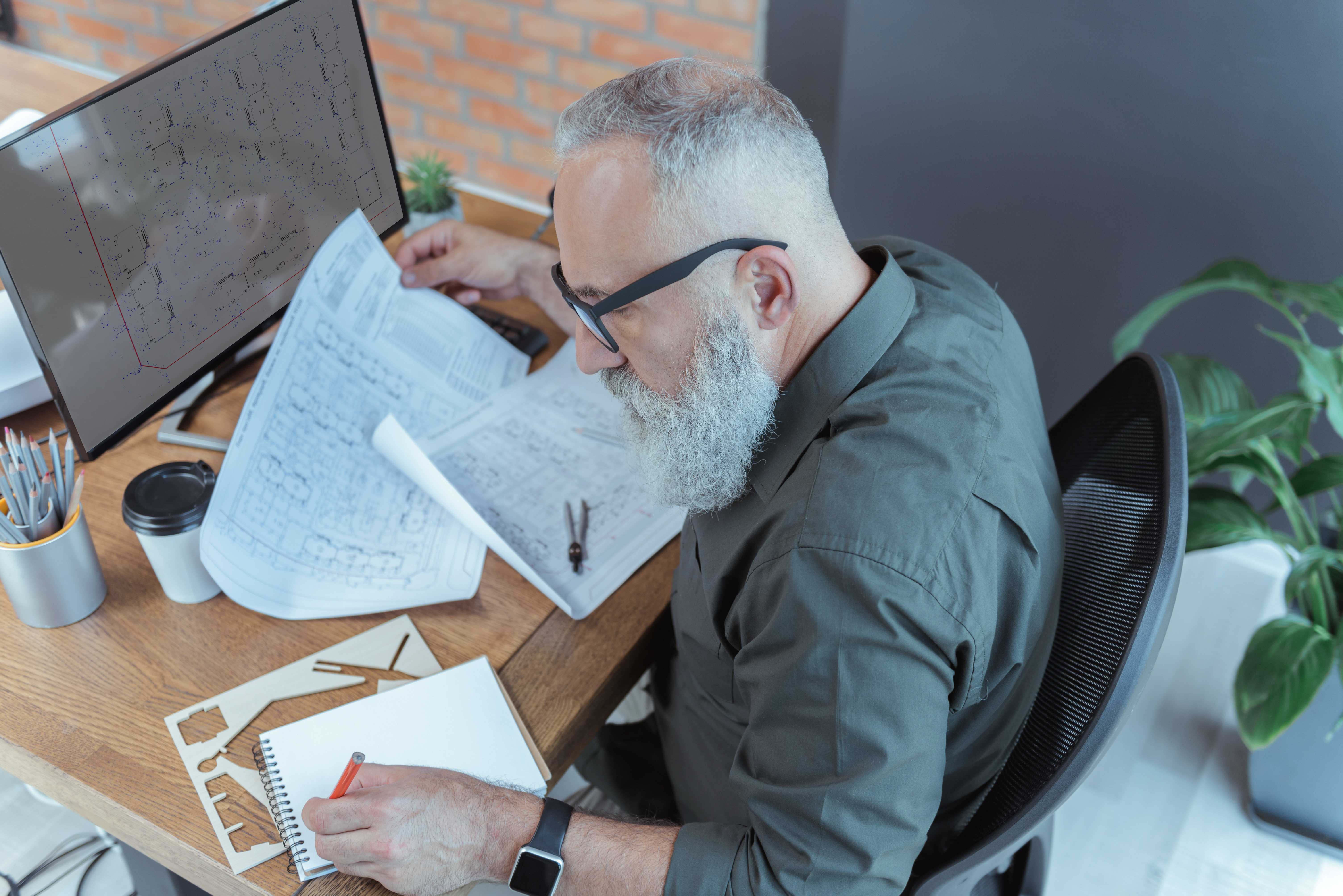 Estimator reviewing technical drawings at desk